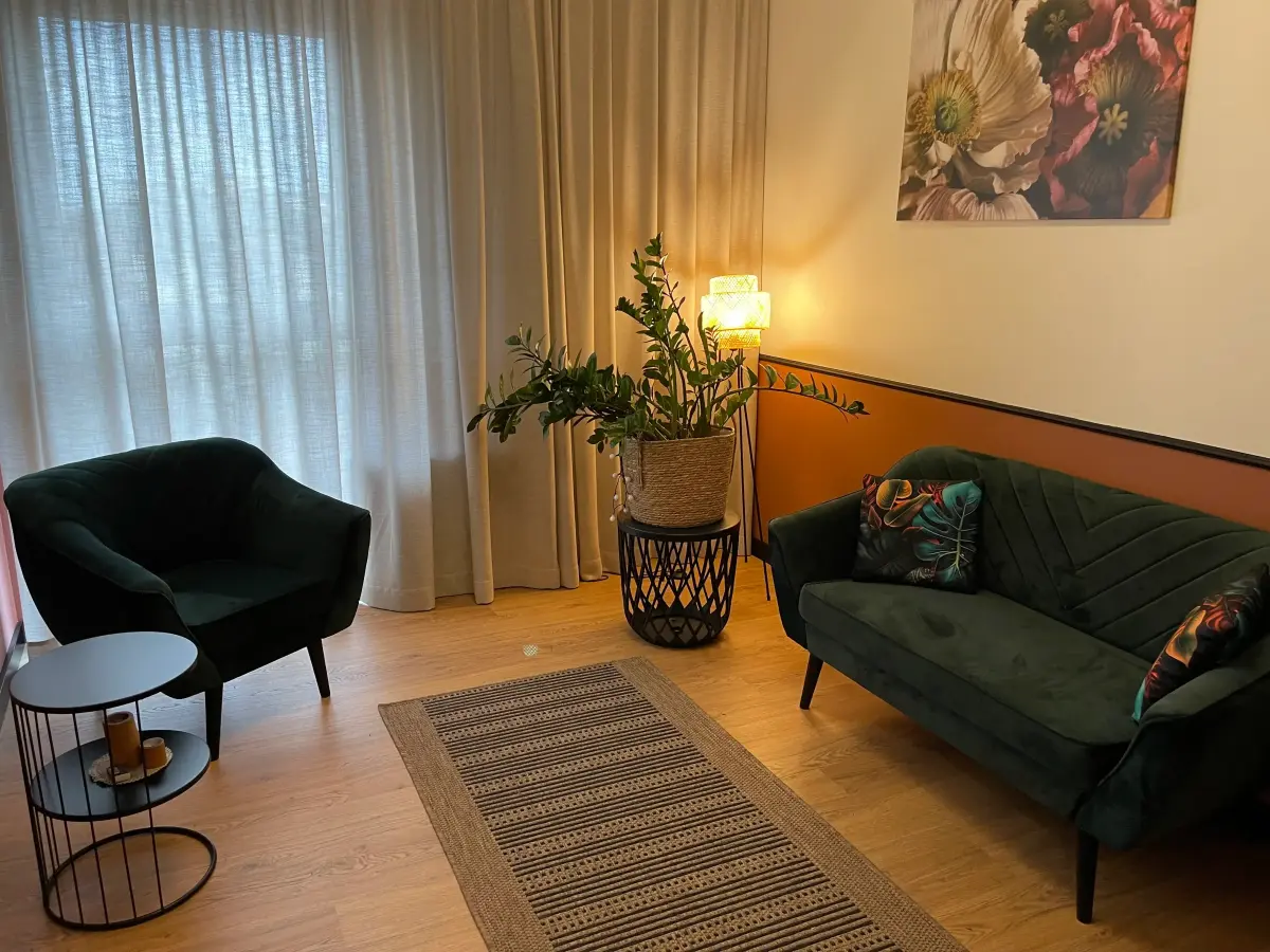Gabinet psychologiczny Kamili Szwejk-Brzozowskiej - sofa, regał i rośliny